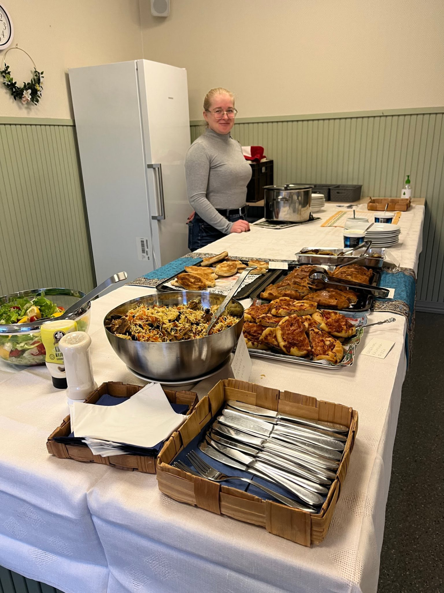 A volunteer serving a communal meal from a buffet table at a community gathering